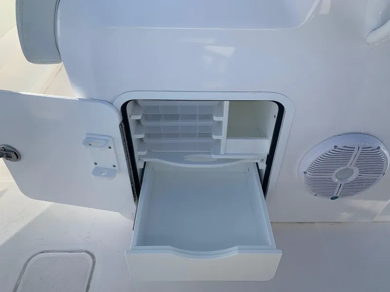 Slide: The Image of Open storage compartment on 2024 Invincible 33 Catamaran with drawer and speaker. - 10
