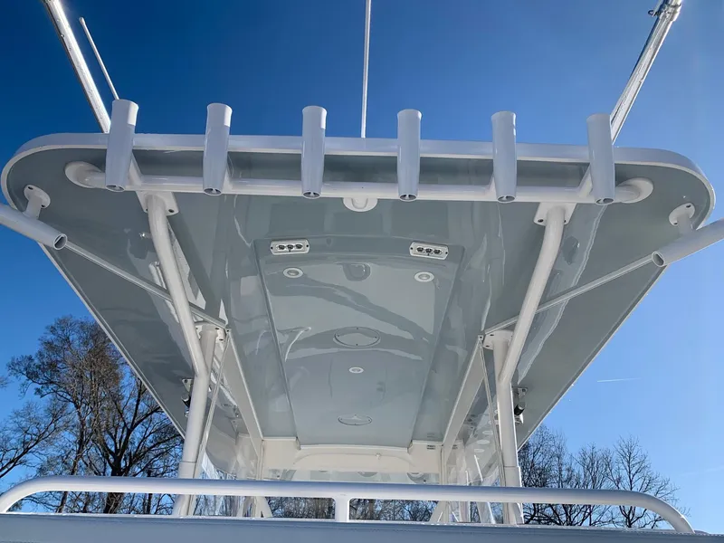 Slide: The Image of 2024 Invincible 33 Catamaran boat top view with rod holders and blue sky background. - 11