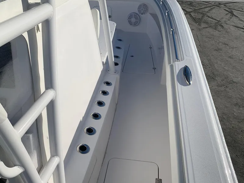 Slide: The Image of 2024 Invincible 33 Catamaran boat deck with rod holders and storage compartments. - 14
