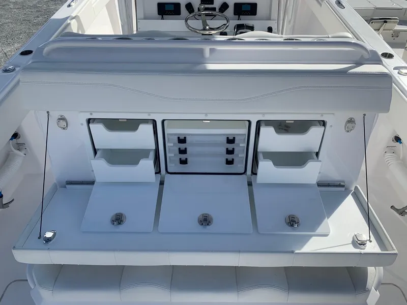 Slide: The Image of 2024 Invincible 33 Catamaran boat interior with storage compartments and control panel. - 19