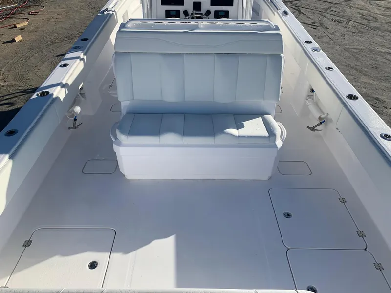 Slide: The Image of 2024 Invincible 33 Catamaran interior with white cushioned seating and storage compartments. - 20