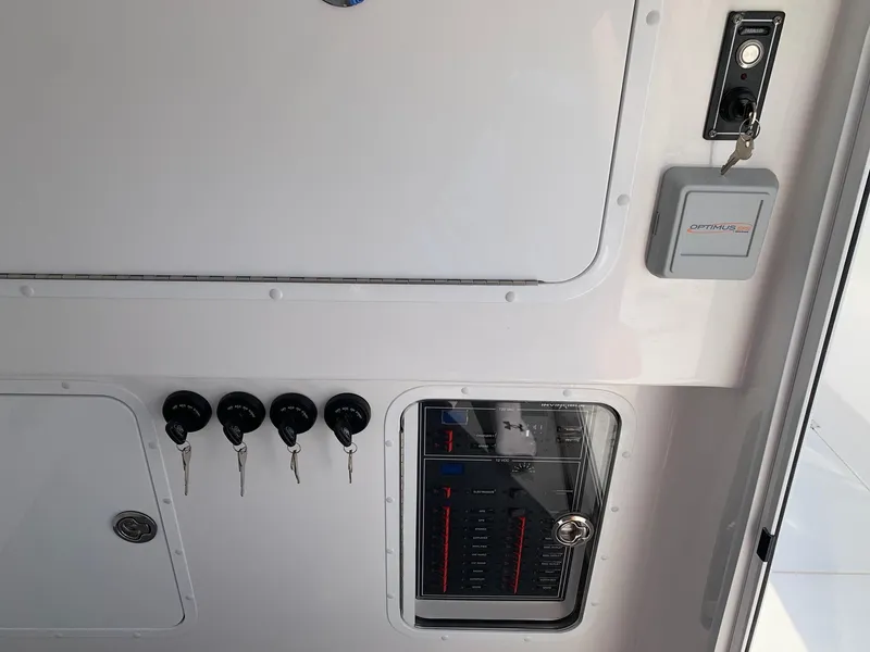 Slide: The Image of Control panel of the 2024 Invincible 35 Catamaran with key switches and circuit breakers. - 16