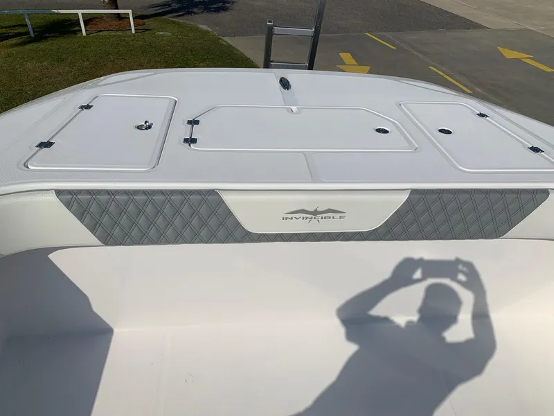 Slide: The Image of 2024 Invincible 35 Catamaran deck with storage compartments and logo. - 22