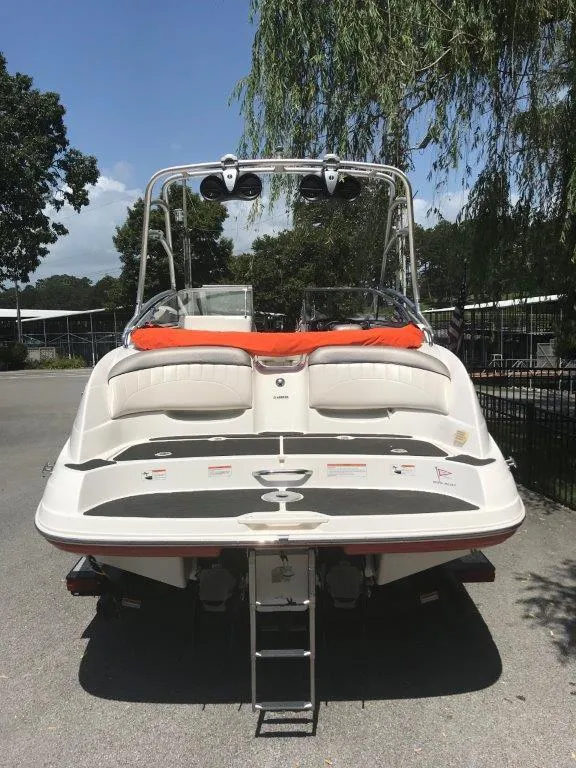 Slide: The Image of 2007 Yamaha AR230 HO boat, rear view with ladder, parked outdoors. - 12