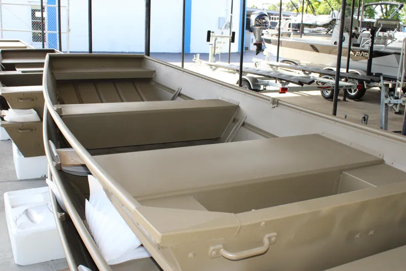Slide: The Image of 2024 G3 Gator Tough 1436 boat, beige interior, displayed in showroom. - 2