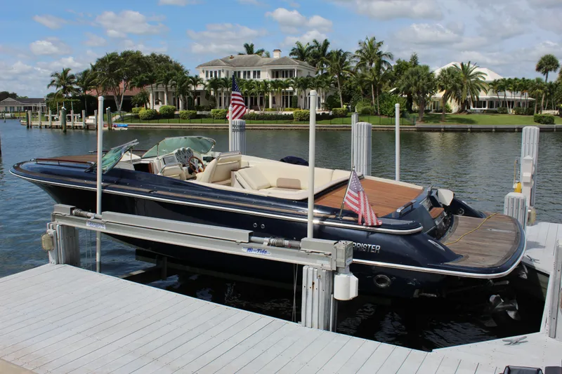 The Image of 2010 Chris-Craft Corsair 28 boat docked by waterfront homes. - 1