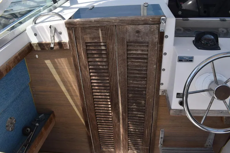 Slide: The Image of 1987 Grady-White Offshore 24 boat interior with wooden door and steering wheel. - 11