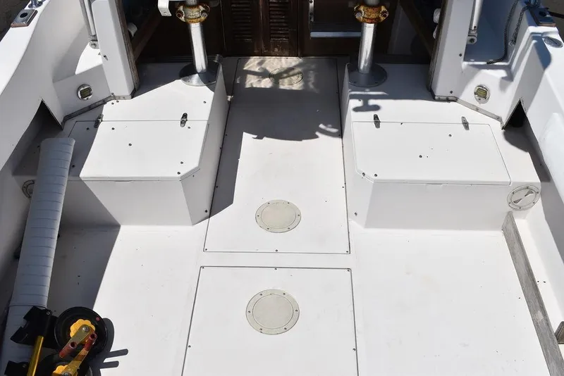 Slide: The Image of 1987 Grady-White Offshore 24 boat deck with storage compartments and fishing rod holders. - 13