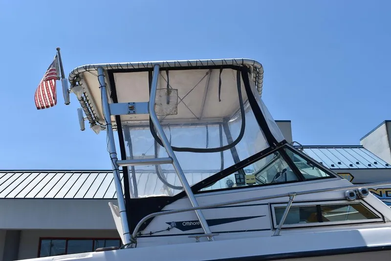 Slide: The Image of 1987 Grady-White Offshore 24 boat with American flag, docked under clear blue sky. - 3