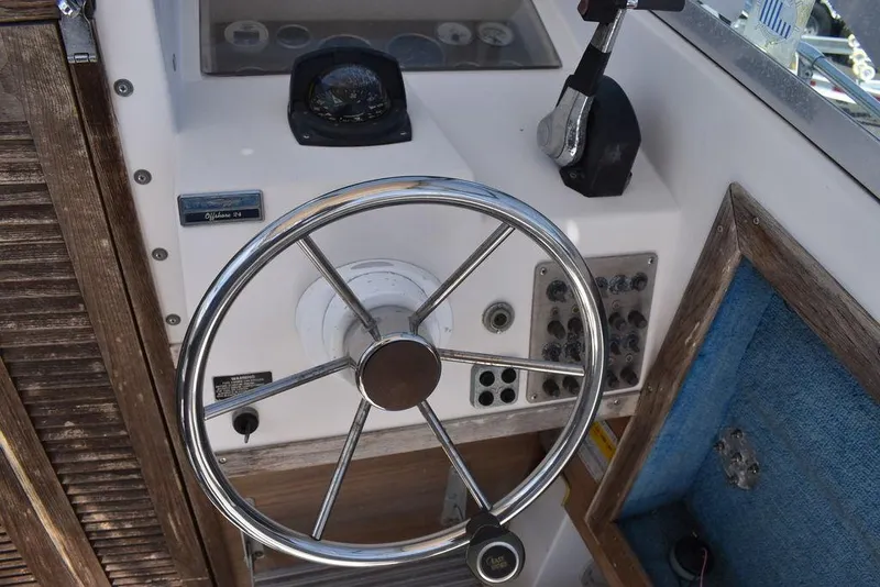 Slide: The Image of 1987 Grady-White Offshore 24 boat helm with steering wheel and control panel. - 35