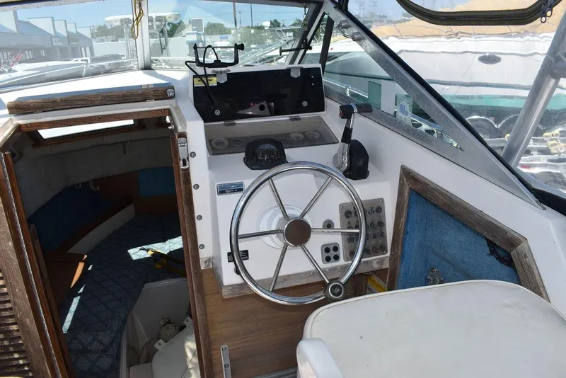 Slide: The Image of 1987 Grady-White Offshore 24 boat helm with steering wheel and cabin entrance. - 38
