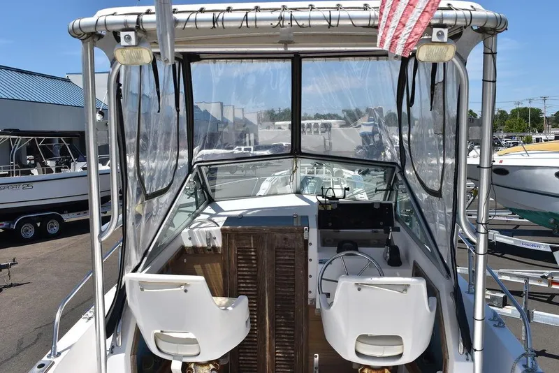 Slide: The Image of 1987 Grady-White Offshore 24 boat cockpit with two white captain chairs and clear canopy. - 9