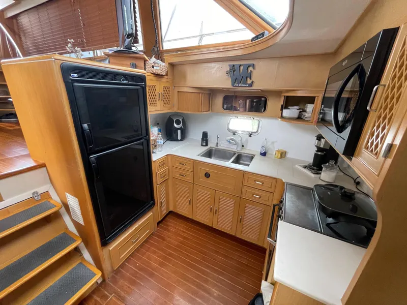 Slide: The Image of 1989 Hi-Star 55 Pilothouse kitchen with wood cabinetry, appliances, and skylight. - 13
