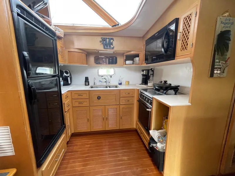Slide: The Image of 1989 Hi-Star 55 Pilothouse kitchen with wood cabinetry, appliances, and skylight. - 14