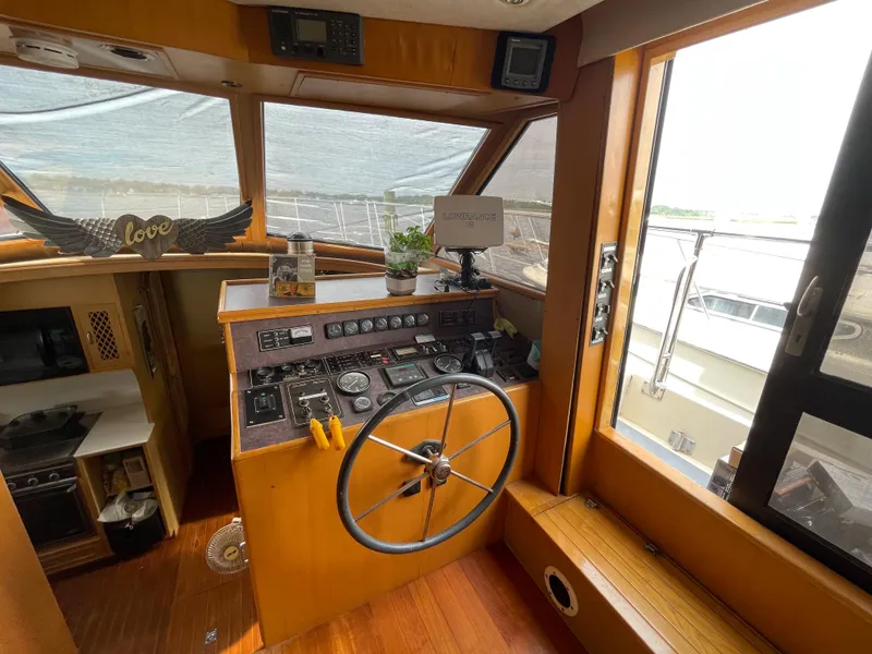 Slide: The Image of 1989 Hi-Star 55 Pilothouse interior with steering wheel, control panel, and nautical decor. - 21