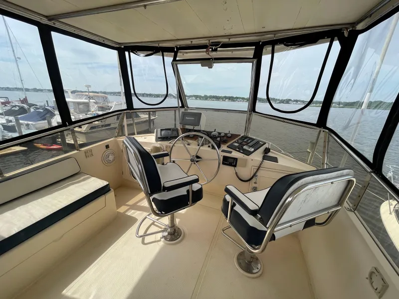 Slide: The Image of 1989 Hi-Star 55 Pilothouse interior with helm, dual seats, and panoramic water view. - 22