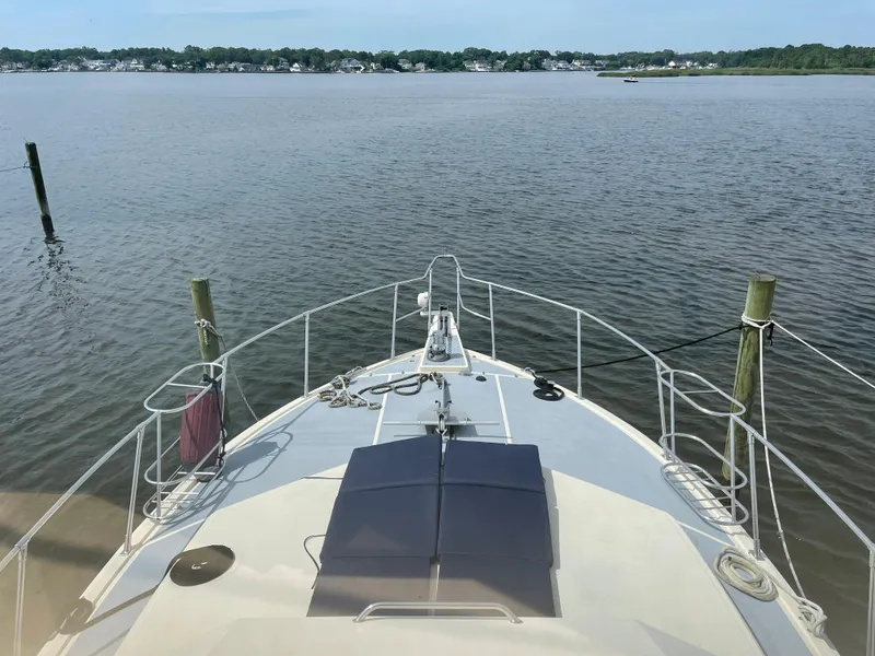 Slide: The Image of 1989 Hi-Star 55 Pilothouse yacht on calm water, scenic shoreline view. - 25