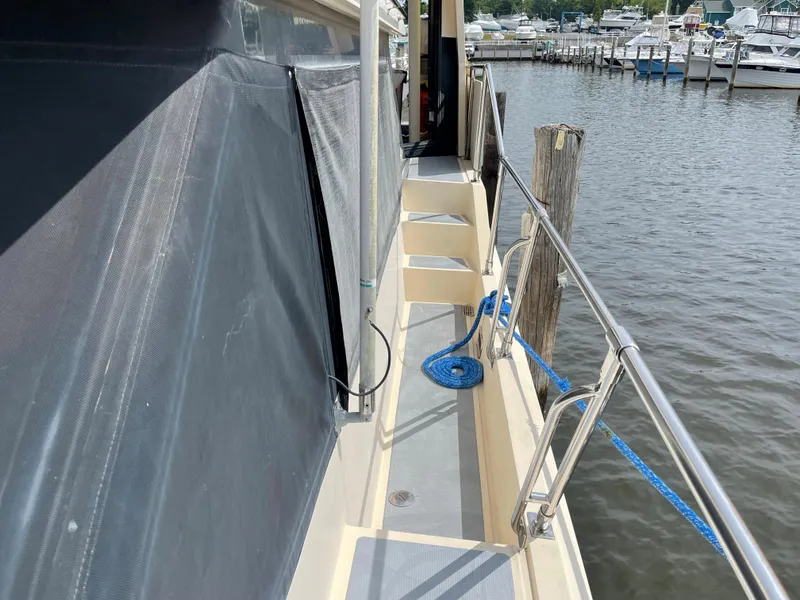 Slide: The Image of 1989 Hi-Star 55 Pilothouse yacht docked, featuring side deck and railing with marina view. - 30