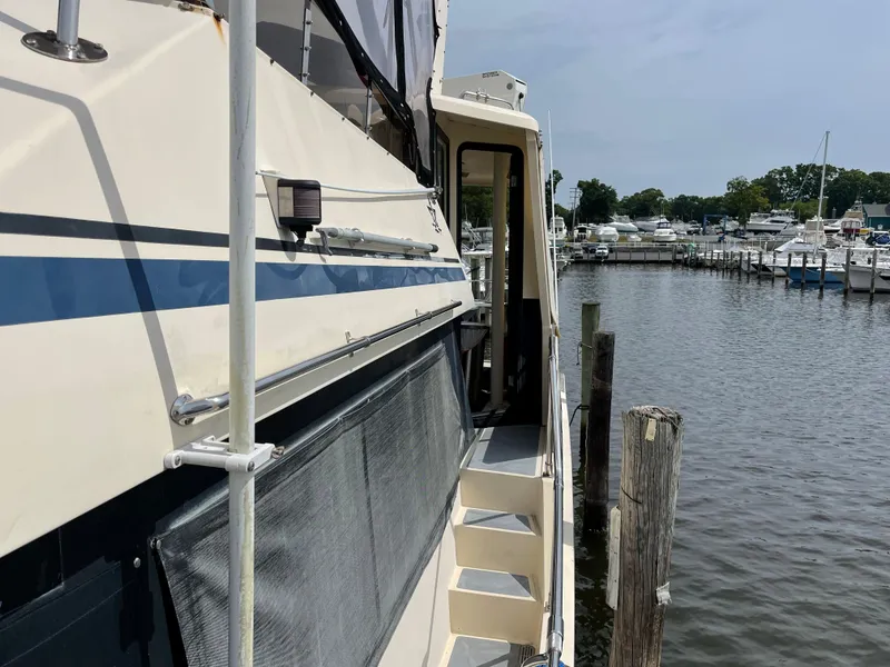Slide: The Image of 1989 Hi-Star 55 Pilothouse yacht docked at marina, side view with water and boats. - 31