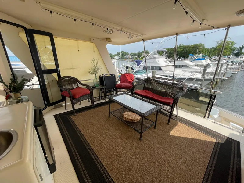 Slide: The Image of 1989 Hi-Star 55 Pilothouse yacht interior with wicker furniture and marina view. - 32