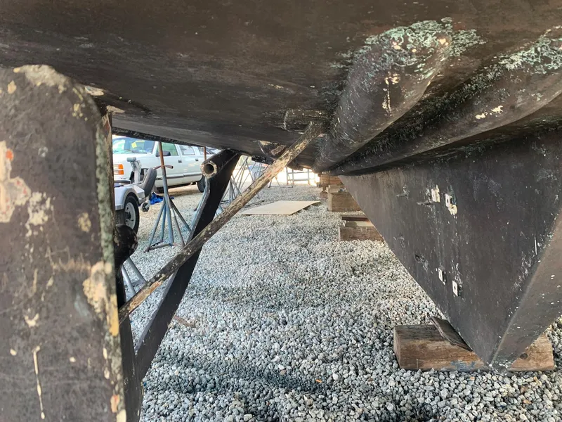 Slide: The Image of Underside of a 1970 Custom Dive Vessel on a gravel lot. - 19