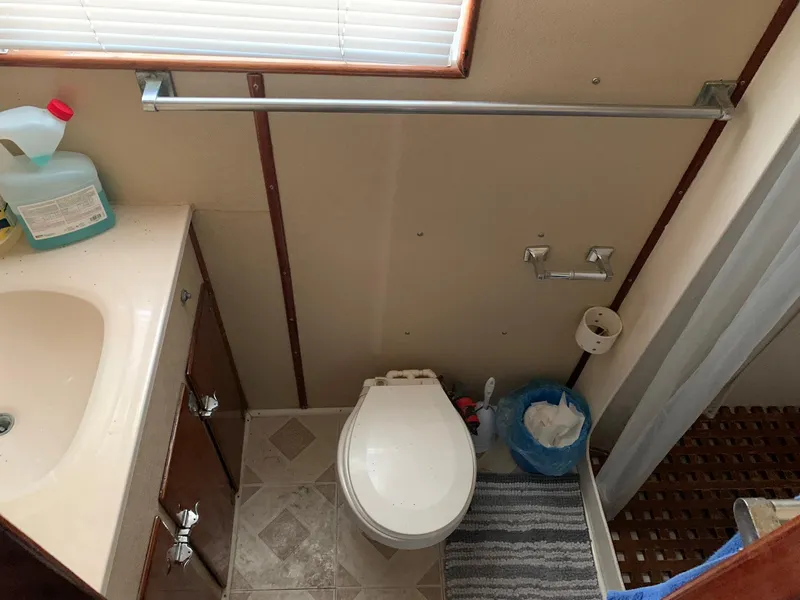 Slide: The Image of 1970 Custom Dive Vessel bathroom with sink, toilet, and striped rug. - 22