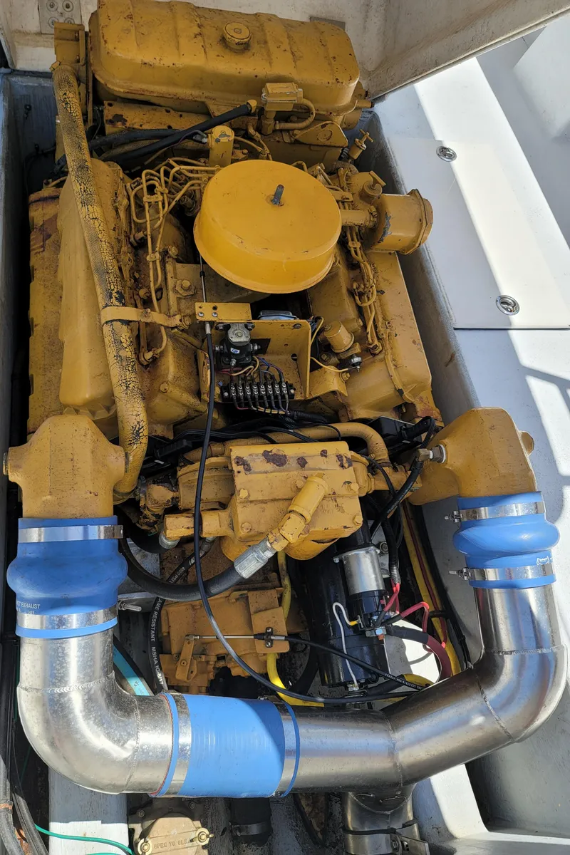 Slide: The Image of 1989 C-Hawk 29 boat engine with yellow components and blue hoses. - 15