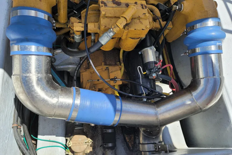 Slide: The Image of 1989 C-Hawk 29 engine compartment with stainless steel exhaust pipes and blue silicone connectors. - 16