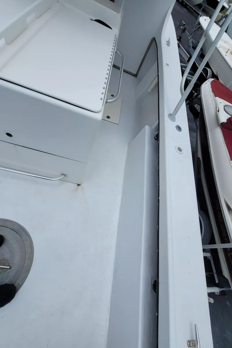 Slide: The Image of 1989 C-Hawk 29 boat deck with storage compartments and seating. - 20