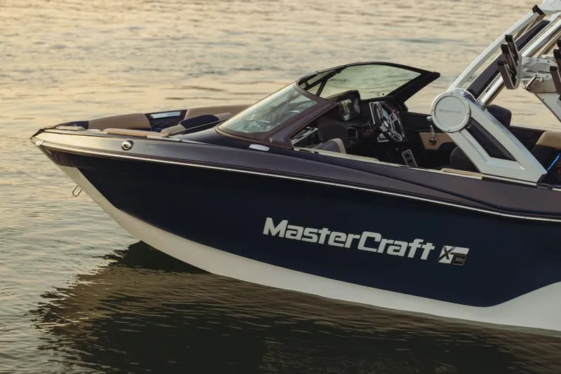 Slide: The Image of 2023 MasterCraft XT22 T boat on calm water at sunset. - 1