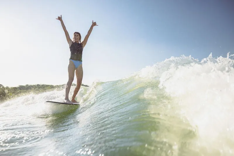 Slide: The Image of Person wakesurfing behind a 2023 MasterCraft XT22 T boat on a sunny day. - 15