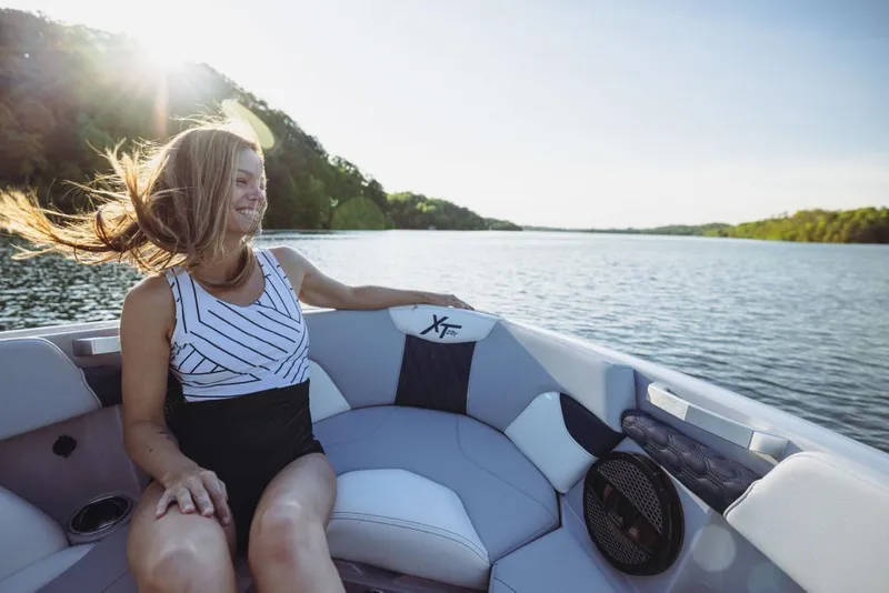 Slide: The Image of Woman enjoying a ride on a 2023 MasterCraft XT22 T boat on a sunny lake. - 19