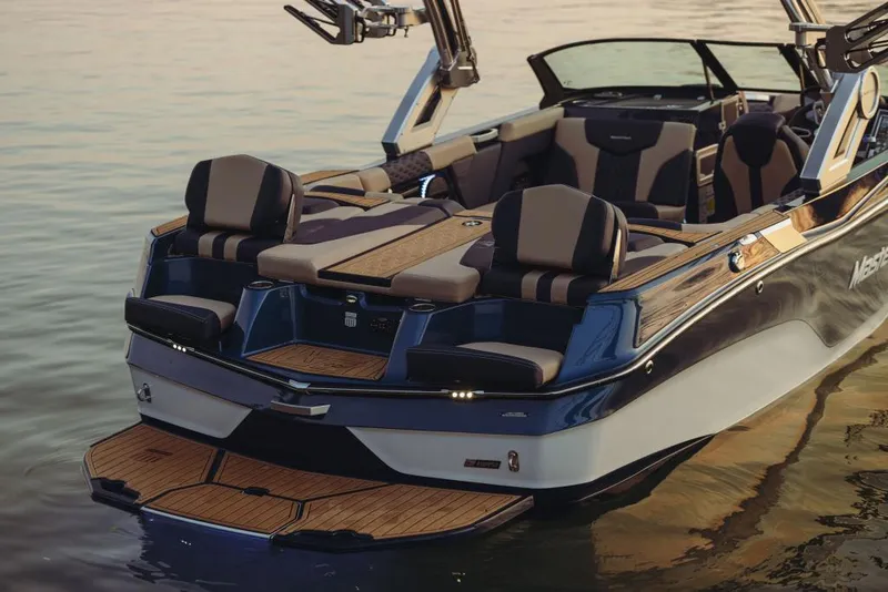 Slide: The Image of 2023 MasterCraft XT22 T boat with luxurious seating and teak deck on calm water. - 2