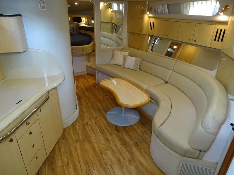 Slide: The Image of 2001 Sea Ray 410 Sundancer interior with curved seating and wooden flooring. - 10