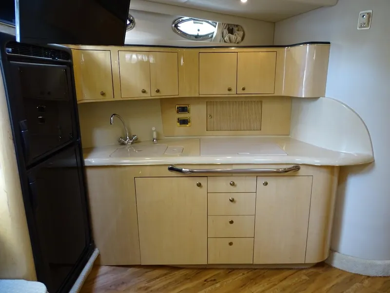 Slide: The Image of 2001 Sea Ray 410 Sundancer yacht kitchen with wooden cabinets and modern appliances. - 11