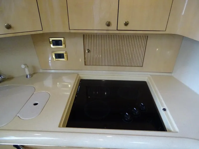 Slide: The Image of 2001 Sea Ray 410 Sundancer kitchen with stovetop and cabinets. - 12