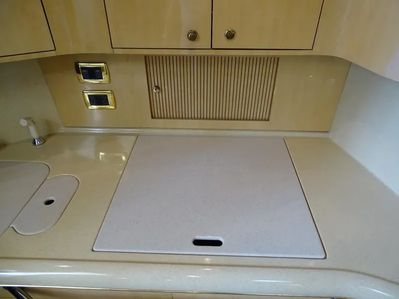 Slide: The Image of 2001 Sea Ray 410 Sundancer kitchen countertop with sink and stove cover. - 13