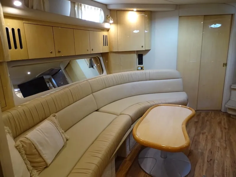 Slide: The Image of Interior of 2001 Sea Ray 410 Sundancer with beige leather seating and wooden table. - 15