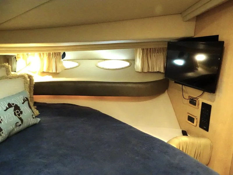 Slide: The Image of Interior cabin of 2001 Sea Ray 410 Sundancer with bed, TV, and portholes. - 17