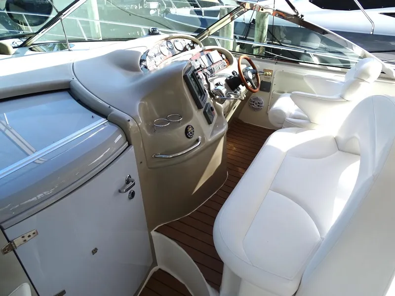 Slide: The Image of Cockpit of 2001 Sea Ray 410 Sundancer with white seating and wooden flooring. - 21