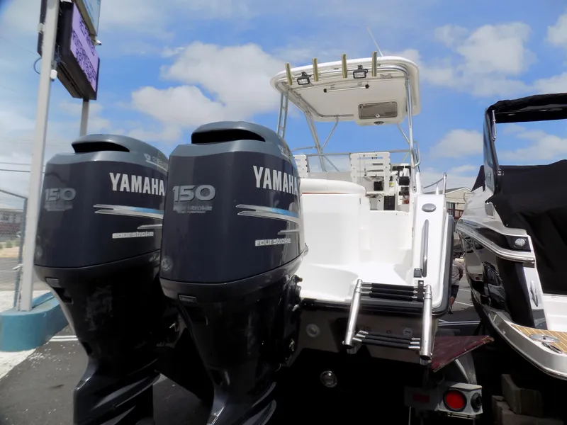 Slide: The Image of 2006 Century 24 Walkaround boat with dual Yamaha 150 engines, docked under a clear sky. - 3