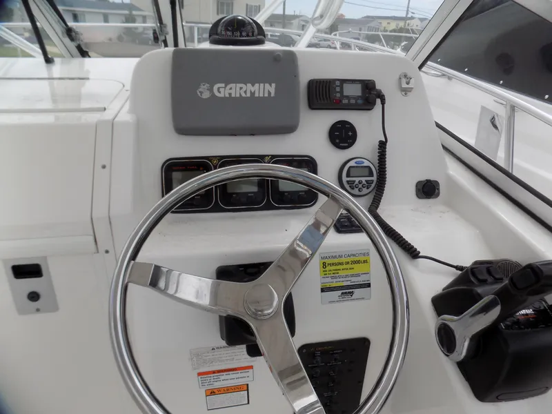 Slide: The Image of 2006 Century 24 Walkaround boat dashboard with Garmin navigation system and steering wheel. - 7