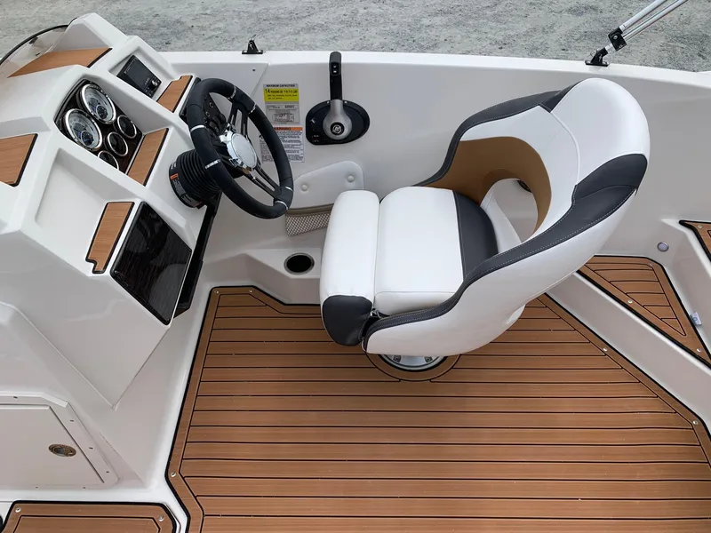 Slide: The Image of 2024 Starcraft SVX 211 boat interior with captain's chair and steering console. - 11