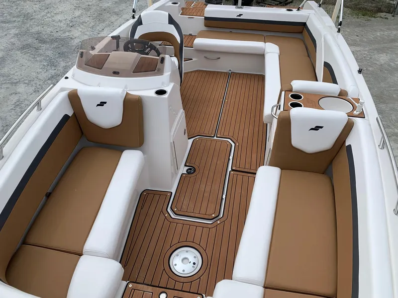 Slide: The Image of 2024 Starcraft SVX 211 boat interior with tan and white seating, wood flooring. - 13
