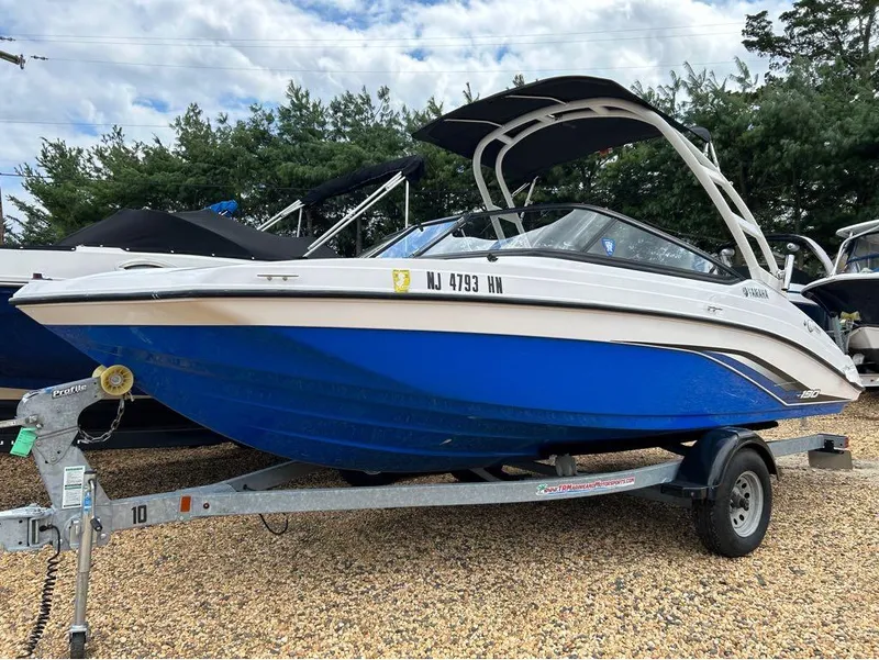 The Image of 2020 Yamaha Boats AR 190 on trailer, blue and white, parked outdoors. - 1