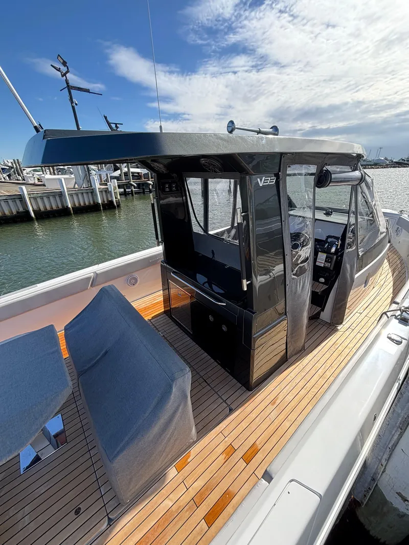 Slide: The Image of 2023 Schaefer V33 boat with sleek design, docked by the water under a clear sky. - 23