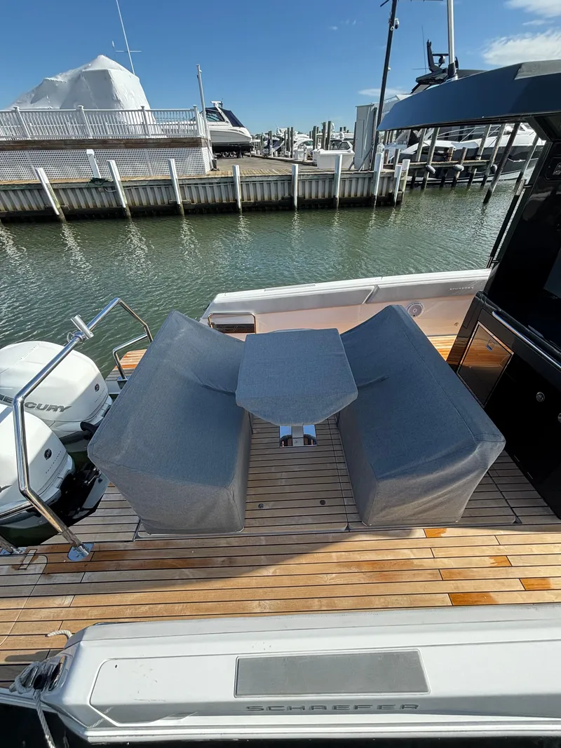 Slide: The Image of 2023 Schaefer V33 boat cruising on a calm waterway with marina in background. - 6