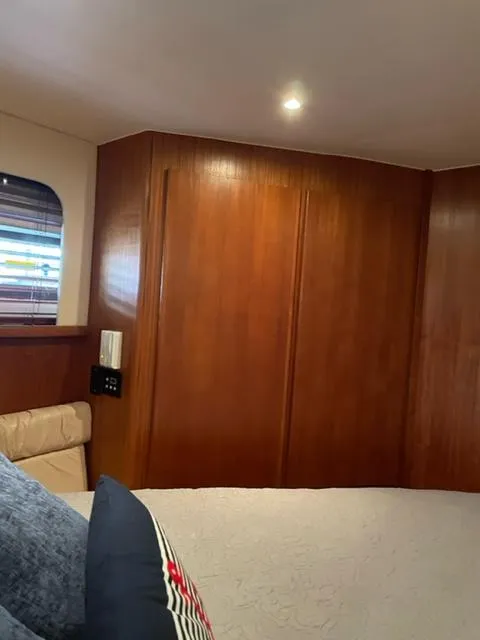 Slide: The Image of 1996 Carver 370 boat interior with white chairs and clear windows in a marina setting. - 37