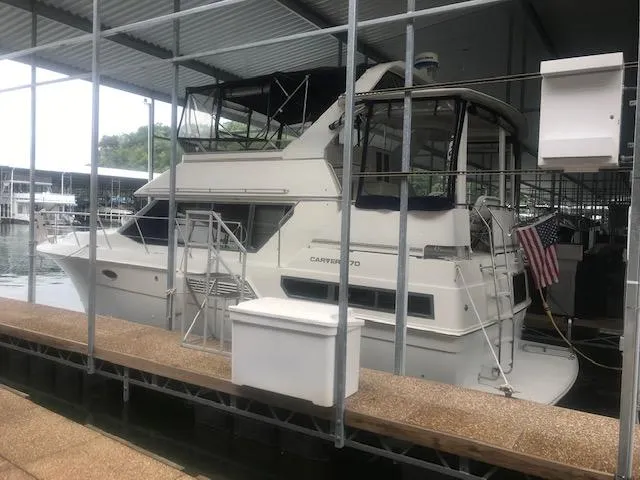 Slide: The Image of 1996 Carver 370 yacht interior with white leather seating and helm chair. - 42