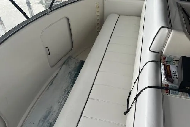 Slide: The Image of Interior of a 1996 Carver 370 boat with white seating and storage compartment. - 43